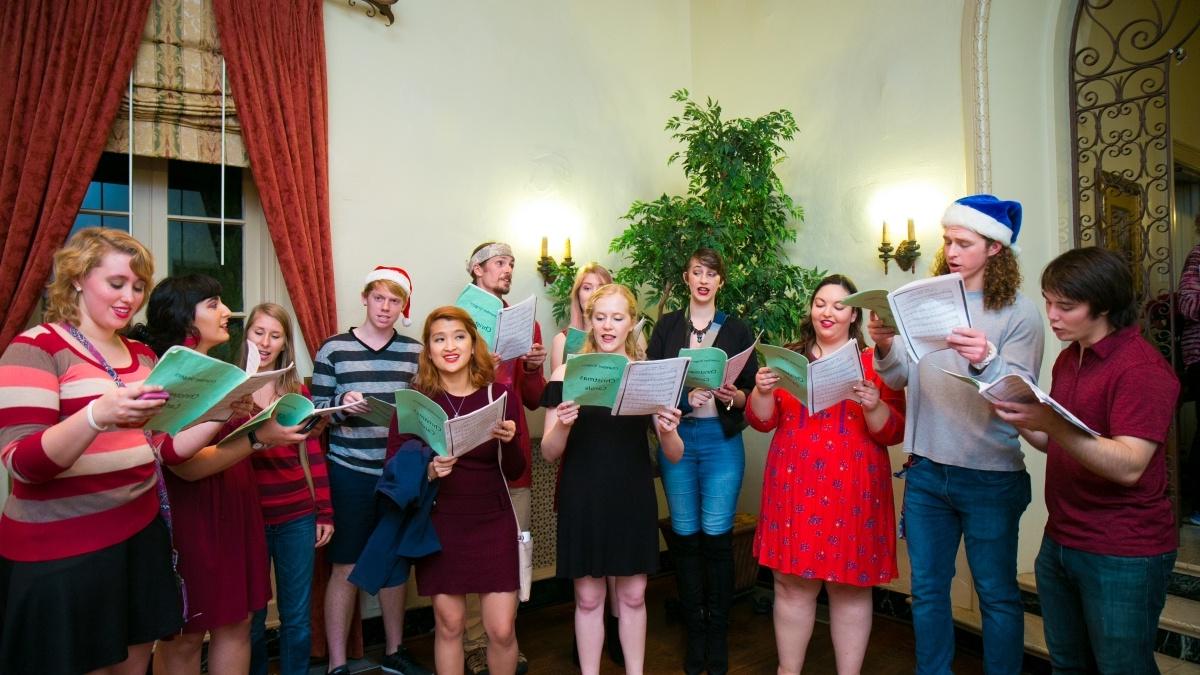 Students in festive dress sing Christmas songs.